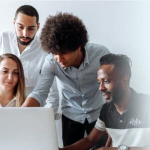 A group of people looking at a laptop