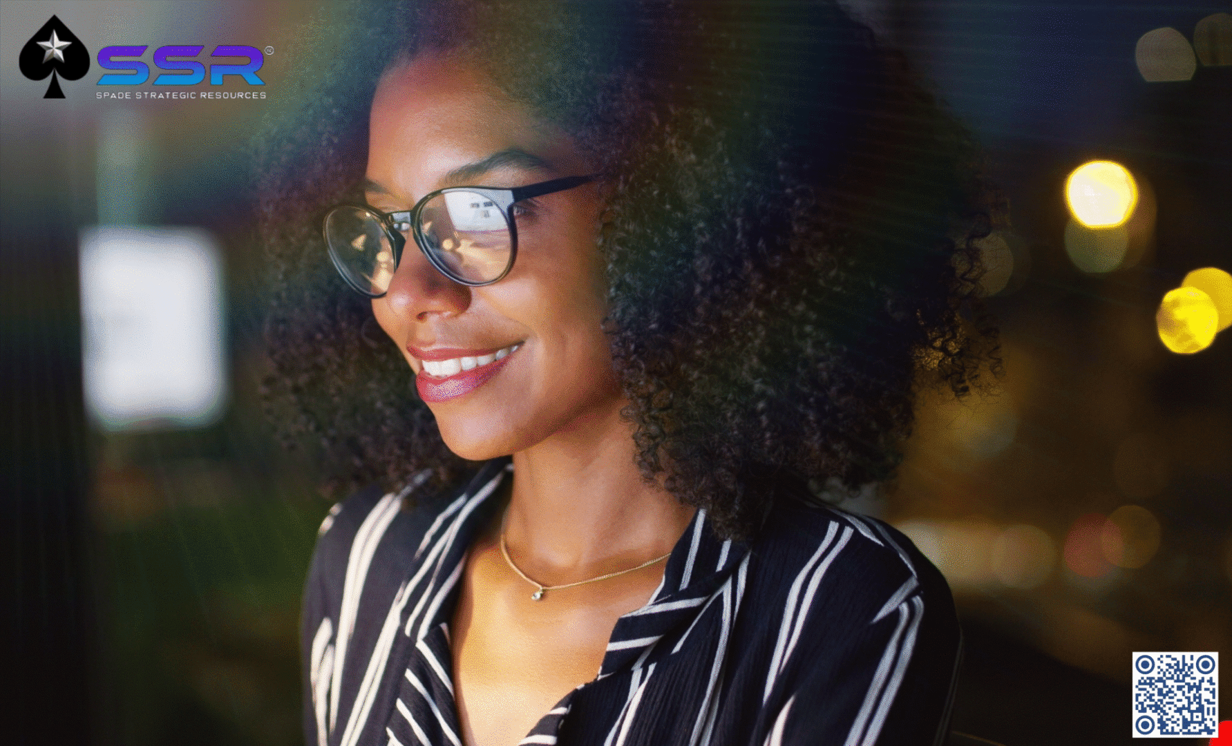Face with Logo Young woman with glasses smiling warmly in soft lighting.