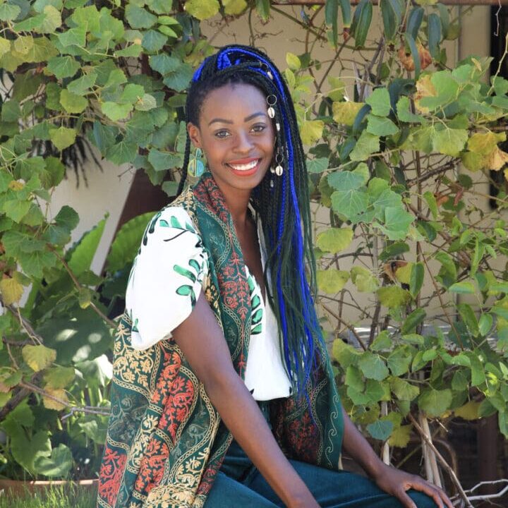 Denise Picture A woman with blue hair sitting in front of some trees