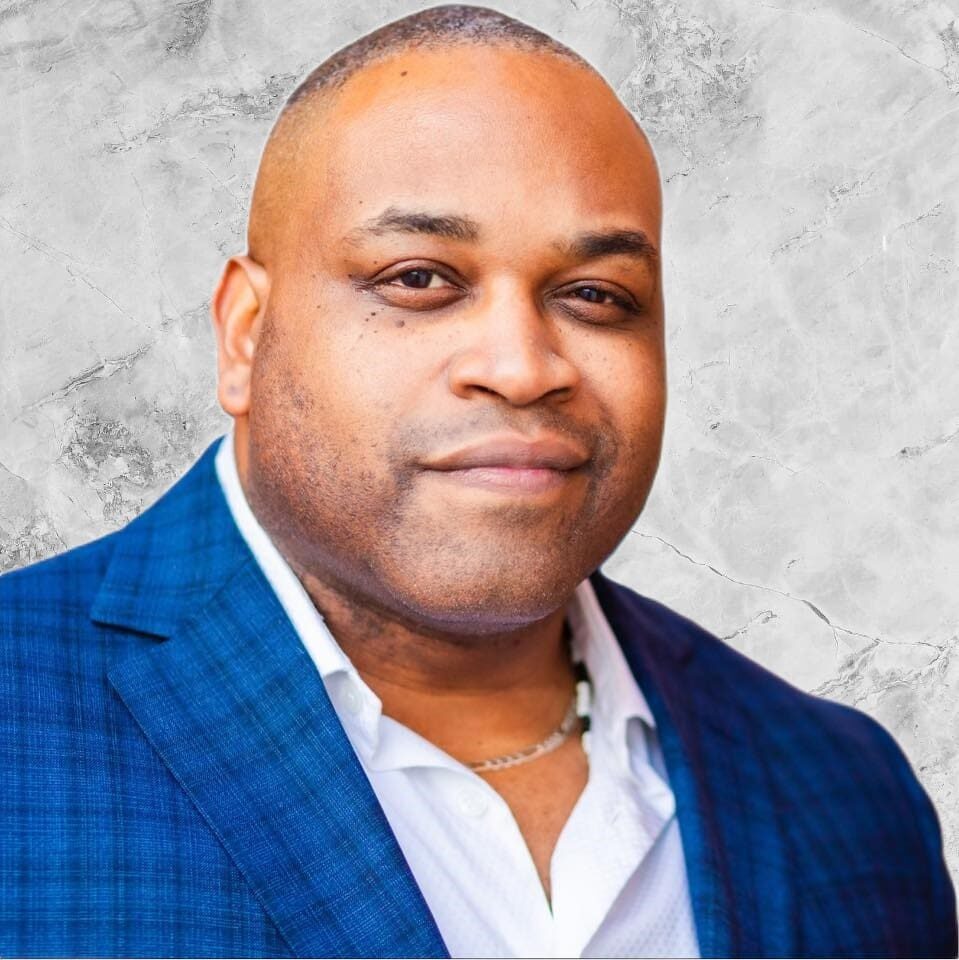 Mr.Bryson A man in a blue jacket and white shirt.